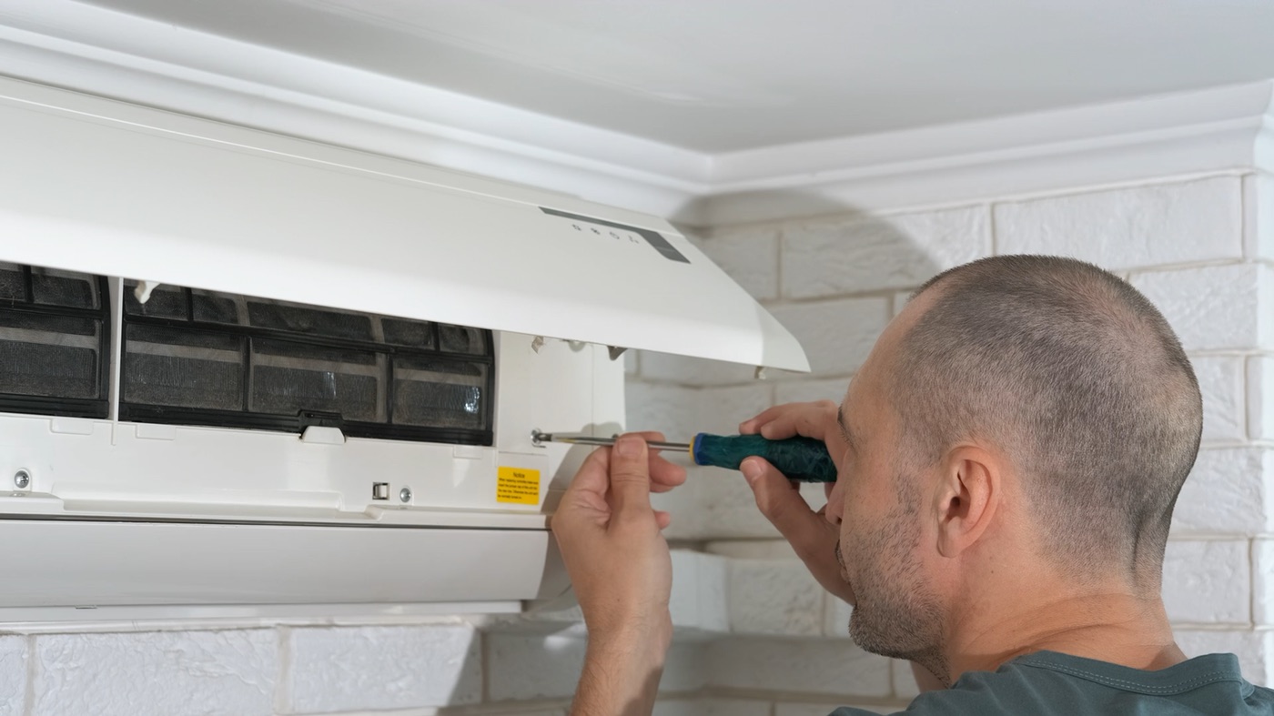 Technician servicing an air conditioning unit.