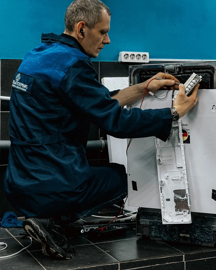 Un profesional reparando un enser doméstico.